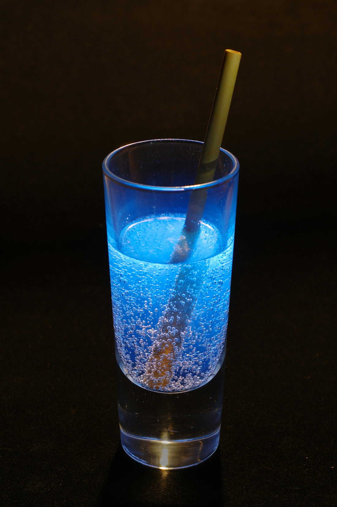 A glass with a straw in it on a table