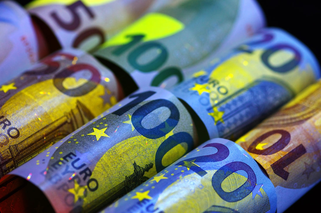 Rolled euro banknotes illuminated under uv light.