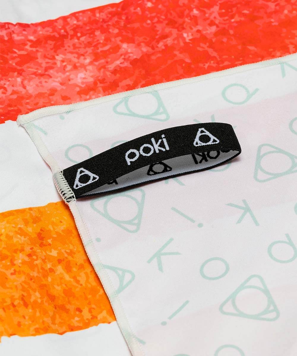 彩虹條紋快乾毛巾的黑色便捷掛帶，品牌標誌 POKI 清晰可見，展示其輕便設計。